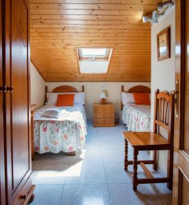 1 dormitorio con 2 camas y techo de madera en Apartamentos Maribel, en Calaceite