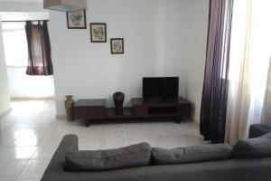 a living room with a couch and a flat screen tv at Casa da Charneca da Caparica in Charneca