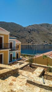 a building next to a lake with a mountain at Captain George in Symi