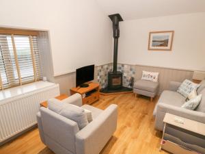 a living room with two couches and a fireplace at Little Netherleigh in Holyhead