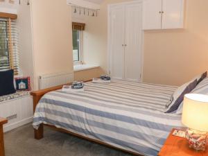 a bedroom with a blue and white striped bed at Little Netherleigh in Holyhead