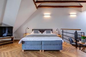 a bedroom with a blue bed and a tv at Design Pension Twenty 20 in Poděbrady