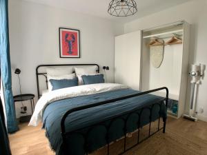 una camera da letto con un grande letto con cuscini blu di Superbe appartement rénové et tout confort à Brest a Brest