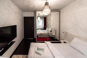 um pequeno quarto com uma cama e um espelho em La Nueve Suite em Brasov