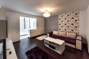 a living room with a couch and a table at La Nueve Suite in Braşov