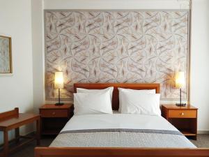 a bedroom with a bed with two night stands and two lamps at Eviali Apartments in Límni
