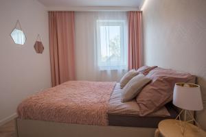 Dormitorio pequeño con cama y ventana en W&K Apartments White&Grey, en Koszalin