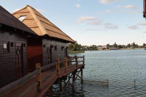 a building on a dock on a body of water at Lake House Senec in Senec