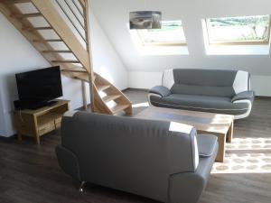 a living room with a couch and a tv at Appartement - Au Vieux Moulin in Leulinghen-Bernes