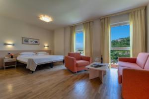 a hotel room with a bed and two chairs at B&B HOTELS Park Hotel Mondovì in Mondovì +51 photos