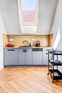 波傑布拉迪的住宿－Design Pension Twenty 20，厨房配有白色橱柜和天窗。