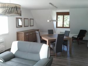 a living room with a table and chairs and a couch at Appartement - Au Vieux Moulin in Leulinghen-Bernes