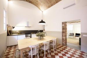 cocina y comedor con mesa de madera y sillas en CASA FILOMENA, en Barcelona