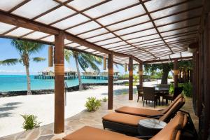 an outdoor patio with a view of the beach at Coconuts Beach Club Resort and Spa in Fausaga