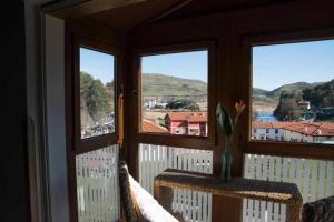 a room with three windows with a view of a town at Casa Rural Mugarri in Poveña
