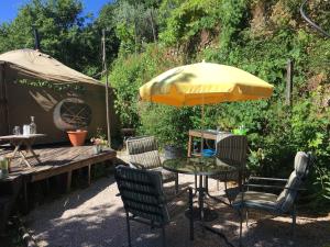 stół i krzesła pod żółtym parasolem w obiekcie Star Gazing Luxury Yurt with RIVER VIEWS, off grid eco living w mieście Vale do Barco