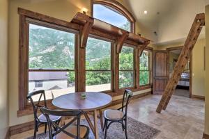 comedor con mesa, sillas y ventanas grandes en Family Retreat with Provo River and Mountain Views!, en Sundance
