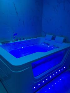 een blauw bad met verlichting in een kamer bij Suite Saint Esteve avec balneo au cœur d'un hameau in Brue-Auriac