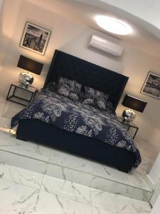 een slaapkamer met een zwart bed en een marmeren vloer bij Suite Saint Esteve avec balneo au cœur d'un hameau in Brue-Auriac