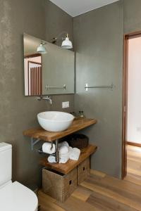 a bathroom with a sink and a mirror at Casitas de Madera O Loureiro in Noya