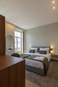 ein Schlafzimmer mit einem großen Bett und einem Spiegel in der Unterkunft ORM - Bolhao Apartments in Porto