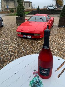 a red car parked next to a bottle of wine at CHAMBRE 1 Balcon in Pons