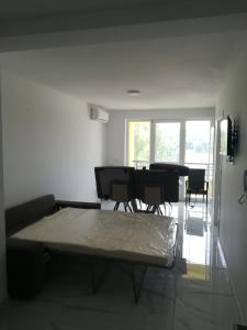 uma sala de estar com uma cama, uma mesa e cadeiras em Venezia Apartman em Veliko Gradište