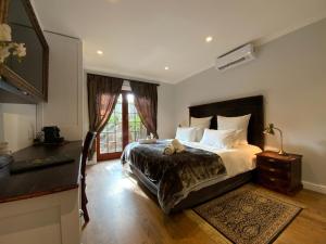 ein Schlafzimmer mit einem Bett und einem Tisch und einem Fenster in der Unterkunft Goblin's Mead in Edgemead