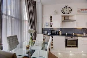 a kitchen with a glass table and a clock on the wall at Bunny Burrow in Whitby