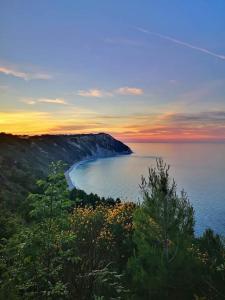 a view of a beach with the sunset in the background at Fior di Loto in Ancona