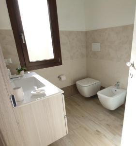 ein Bad mit einem Waschbecken und einem WC in der Unterkunft Guest house Ajo' a mulinu in Teulada