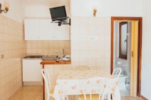 a kitchen with a table and chairs and a sink at Residence Villa la Palmas in Porto Azzurro