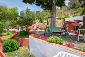 a garden with a swing and flowers at Residence Villa la Palmas in Porto Azzurro