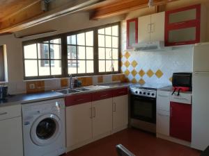 a kitchen with a sink and a washing machine at Varandas Miramar in Angra do Heroísmo