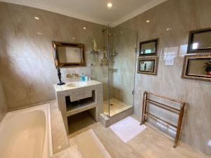 ein Badezimmer mit Dusche, Waschbecken und Badewanne in der Unterkunft Goblin's Mead in Edgemead
