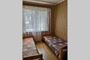 ein Zimmer mit zwei Betten und einem Fenster in der Unterkunft The Lake House "Ausatas" in Dobele