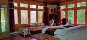 a bedroom with a bed and some windows at Youthok Guest House in Leh