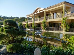 莱斯安格尔斯河滨公寓的公寓大楼前方设有池塘