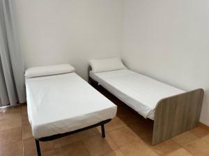 two beds in a room with white sheets at THALASSA by Ponent in Lloret de Mar