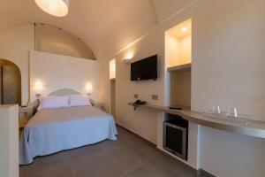 a hotel room with a bed and a tv at Insula Boutique Hotel in Procida