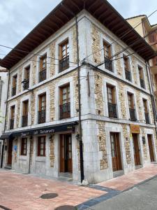 an old stone building on a city street at Hotel Piloñés in Infiesto