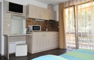 a kitchen with wooden cabinets and a large window at Time out in Sozopol