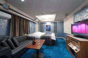 a hotel room with a bed and a flat screen tv at Gifu Movie Movie (Adult Only) in Gifu