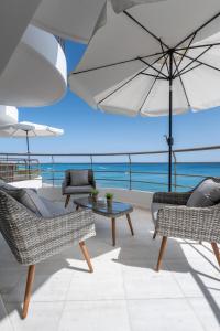 a patio with two chairs and a table and an umbrella at Ierapetra Seaview in Ierapetra