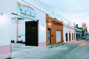 eine leere Straße mit einem Gebäude mit schwarzer Tür in der Unterkunft Hotel John & Rose in Comitán de Domínguez