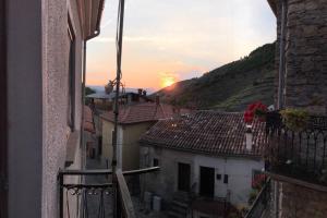 a view from a balcony of a town with the sunset at B&B Casa Vacanze Al Casale in Sasso di Castalda +6 photos
