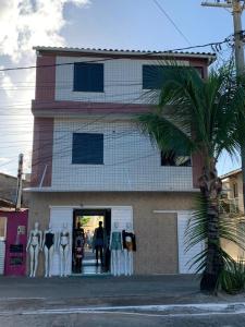 a group of mannequins standing outside of a building at CASA NA PRAÇA DE AREMBEPE in Arembepe