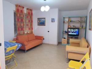 uma sala de estar com um sofá e uma televisão em Dea Apartment em Durrës