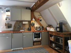 een keuken met grijze kasten en een magnetron bij Ferienwohnung Wildenreuth in Weidenberg
