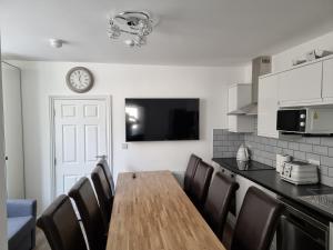 a kitchen with a table and chairs and a clock on the wall at Granada Apartments at Pleasure Beach in Blackpool